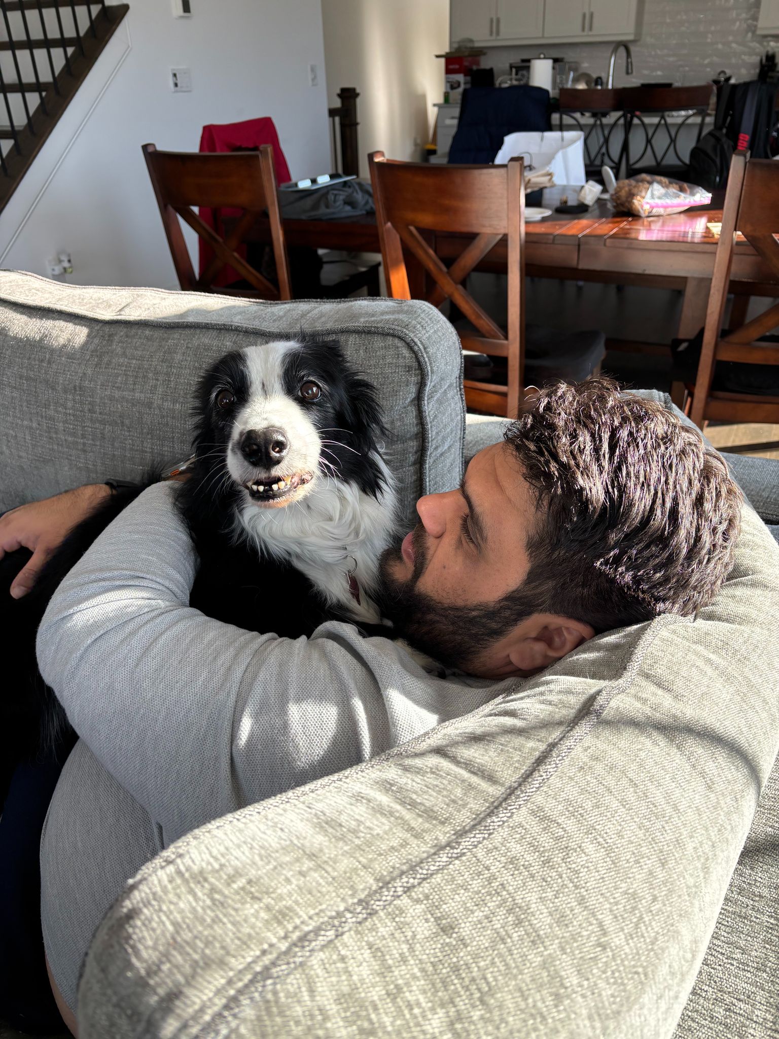 Rahul relaxing on the couch with Luna, his Border Collie.